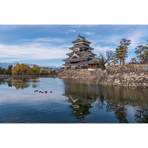 The reflection of the Matsumoto Castle and the castle against the mountain backdrop in Japan